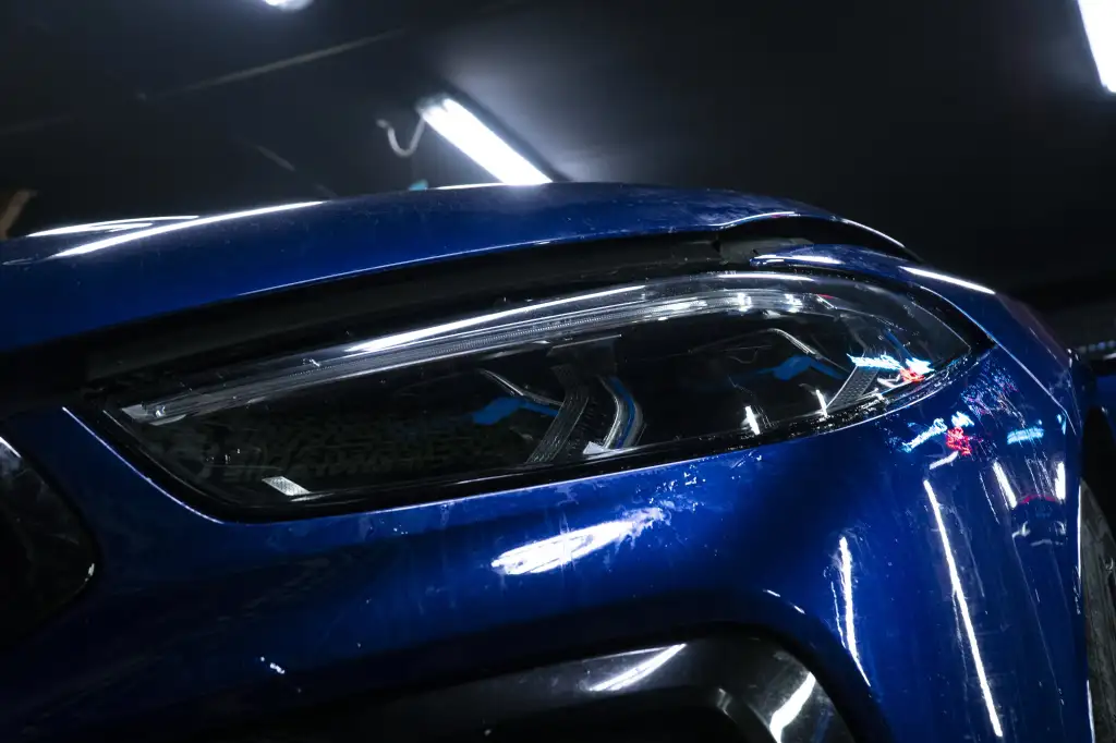 BMW M3 w trakcie montażu folii PPF na reflektorze - Auto Diamond